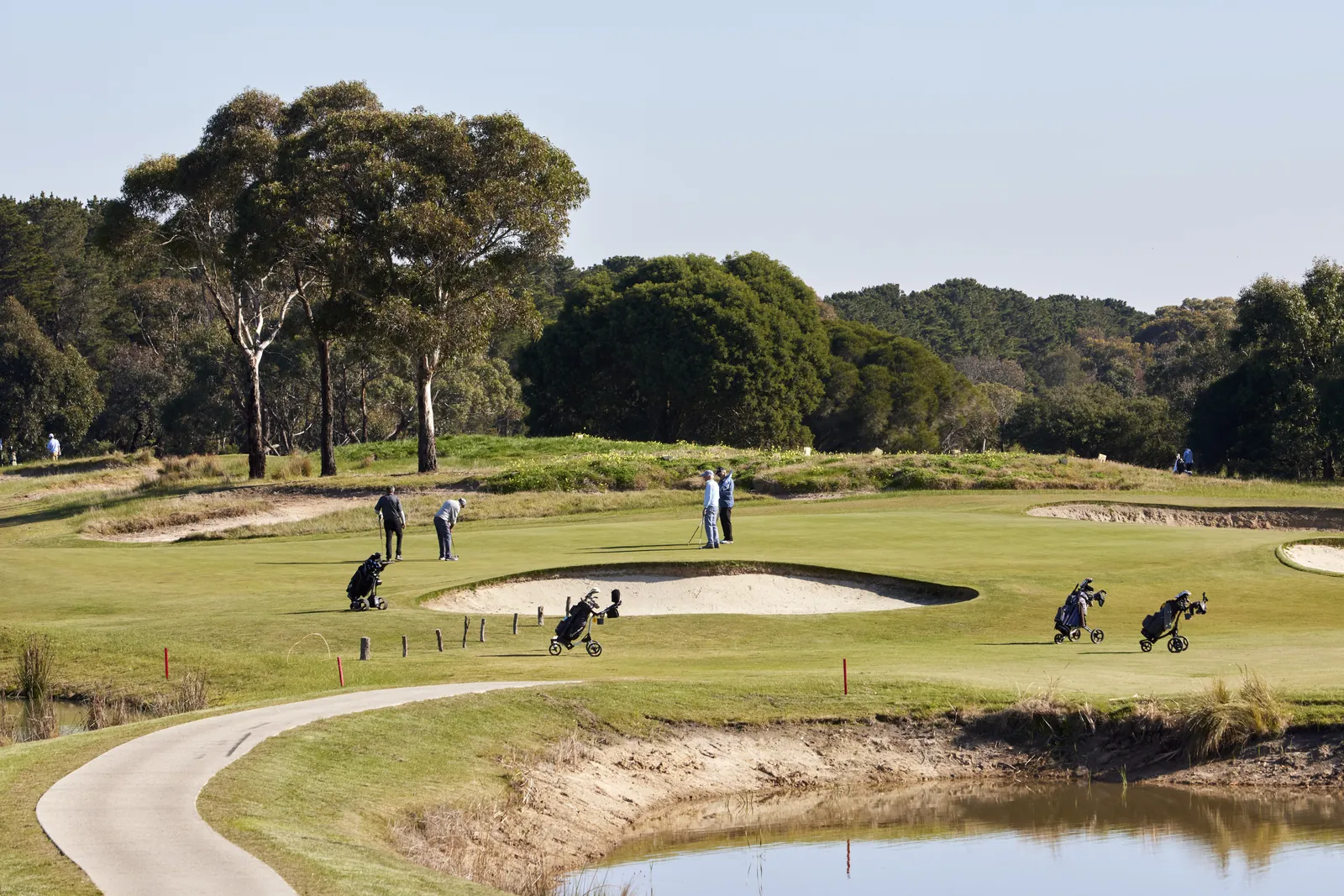 Golfers on a green beside a water hazard at Curlewis Golf Club