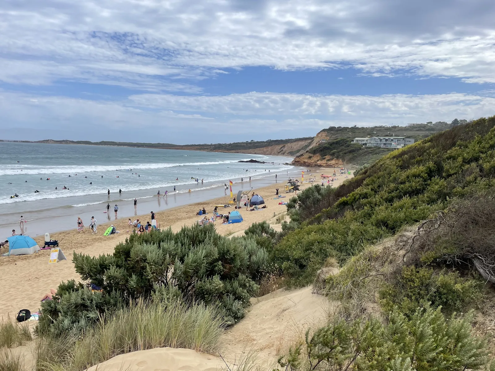 Families on Anglesea main beach below the dunes, looking east along the coast