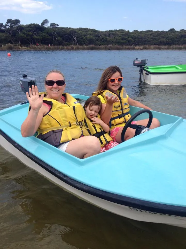 A family waving from a fun boat on the Anglesea River