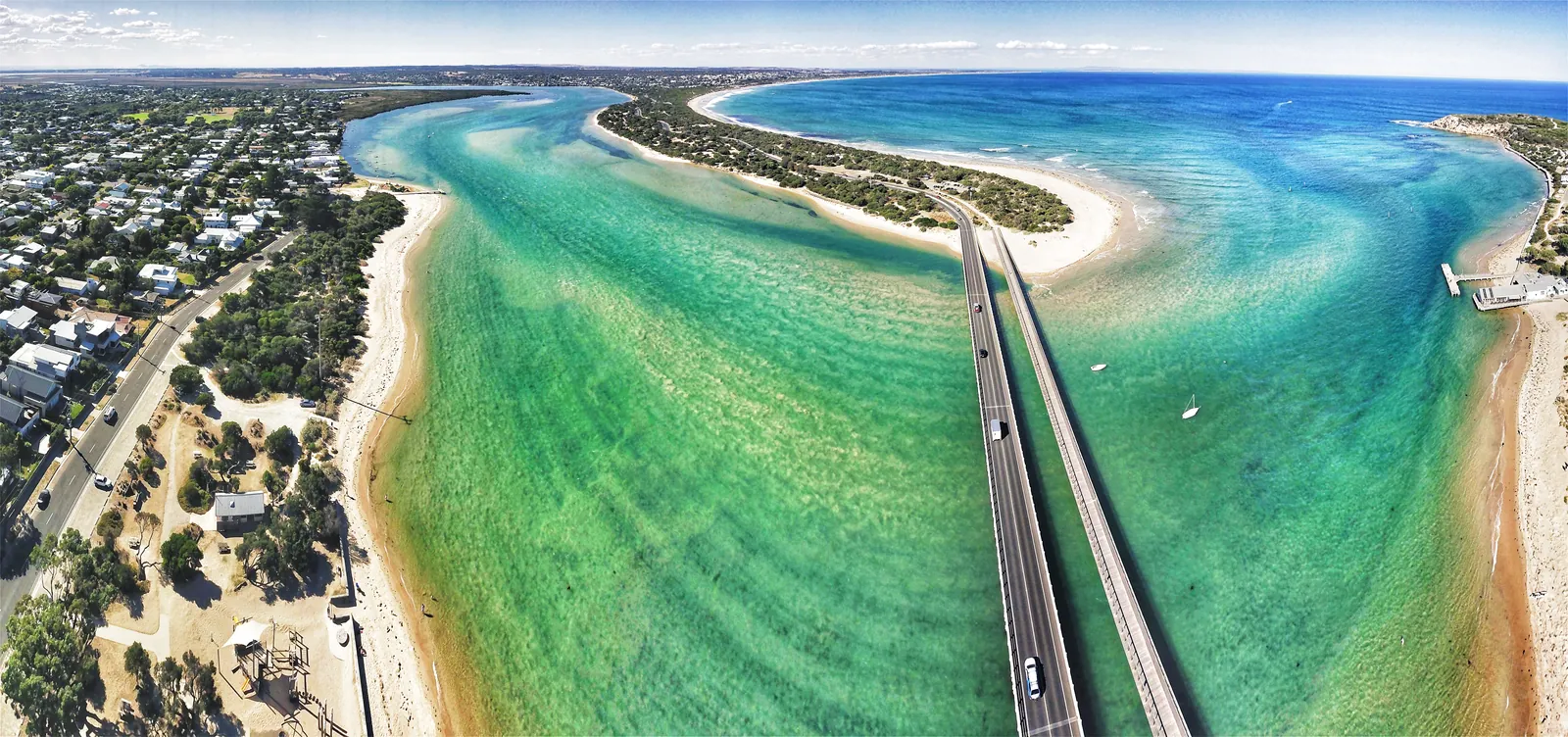 Aerial view of the Barwon River mouth at Barwon Heads, with the bridge to Ocean Grove crossing the green water