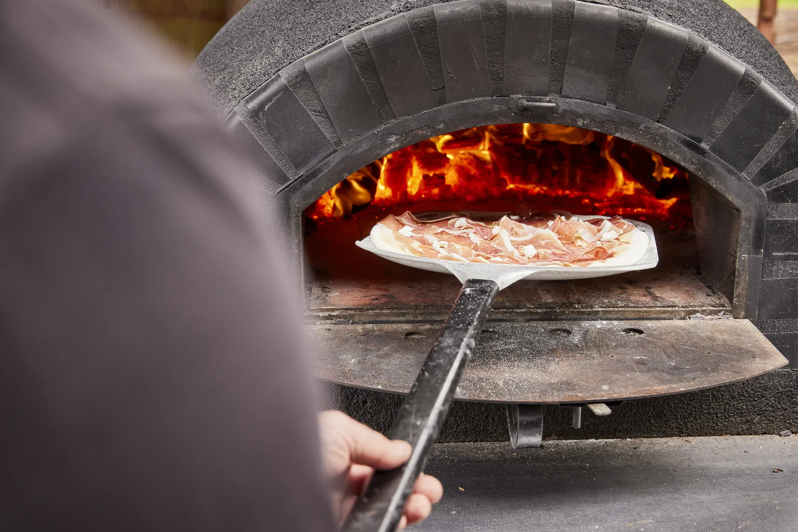 A pizza going into the wood-fired oven at Bellbrae Estate