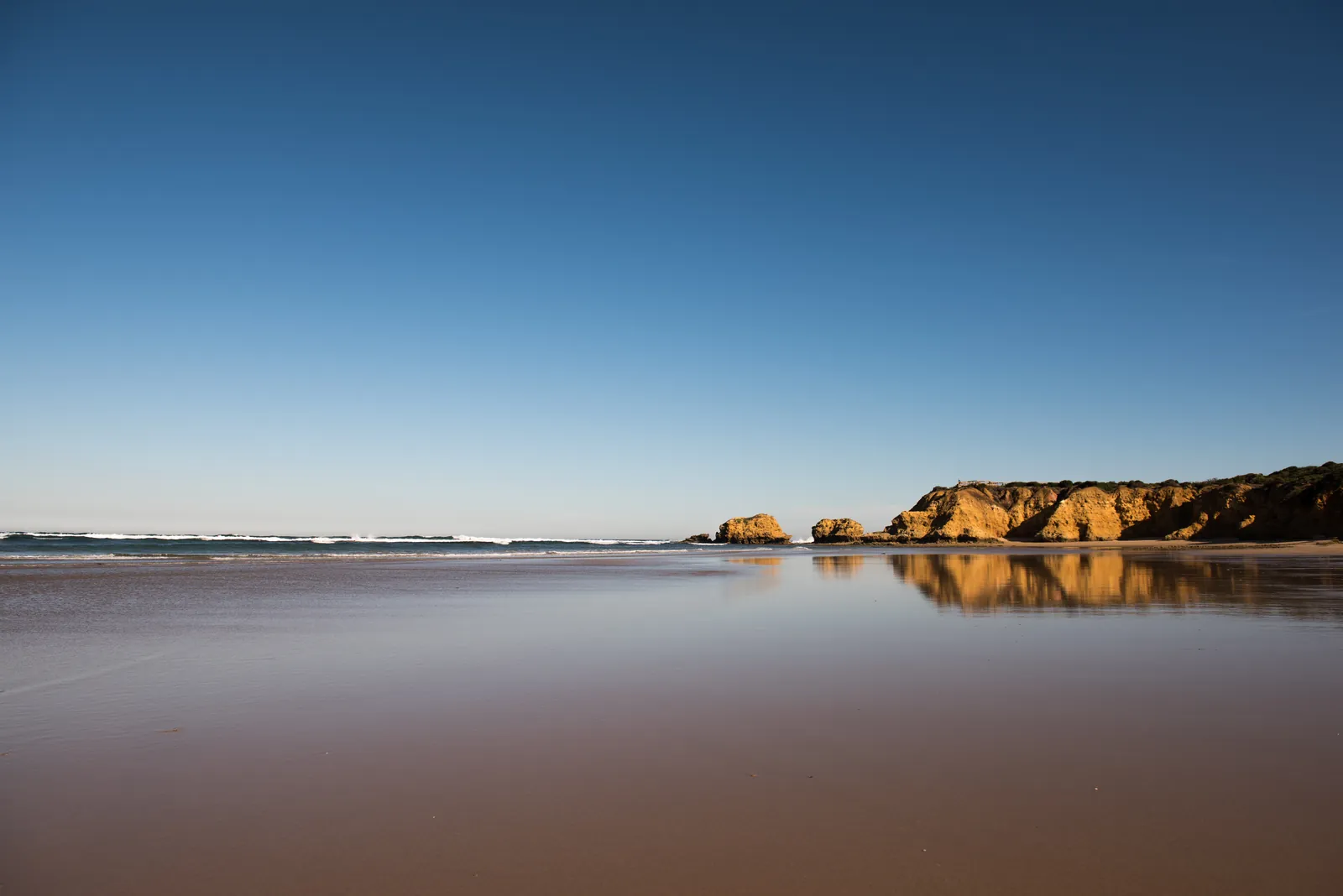 Calm water and sandstone cliffs at Torquay beach