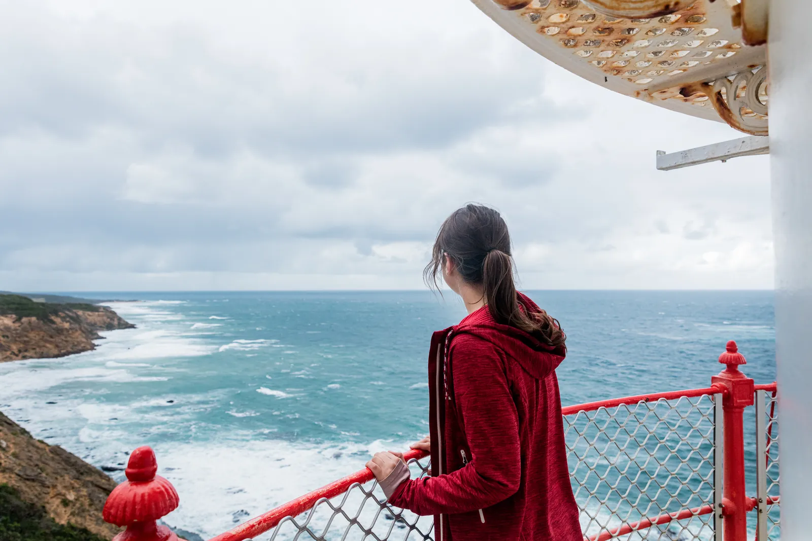 A visitor looking out across the coast from the Cape Otway Lighthouse grounds