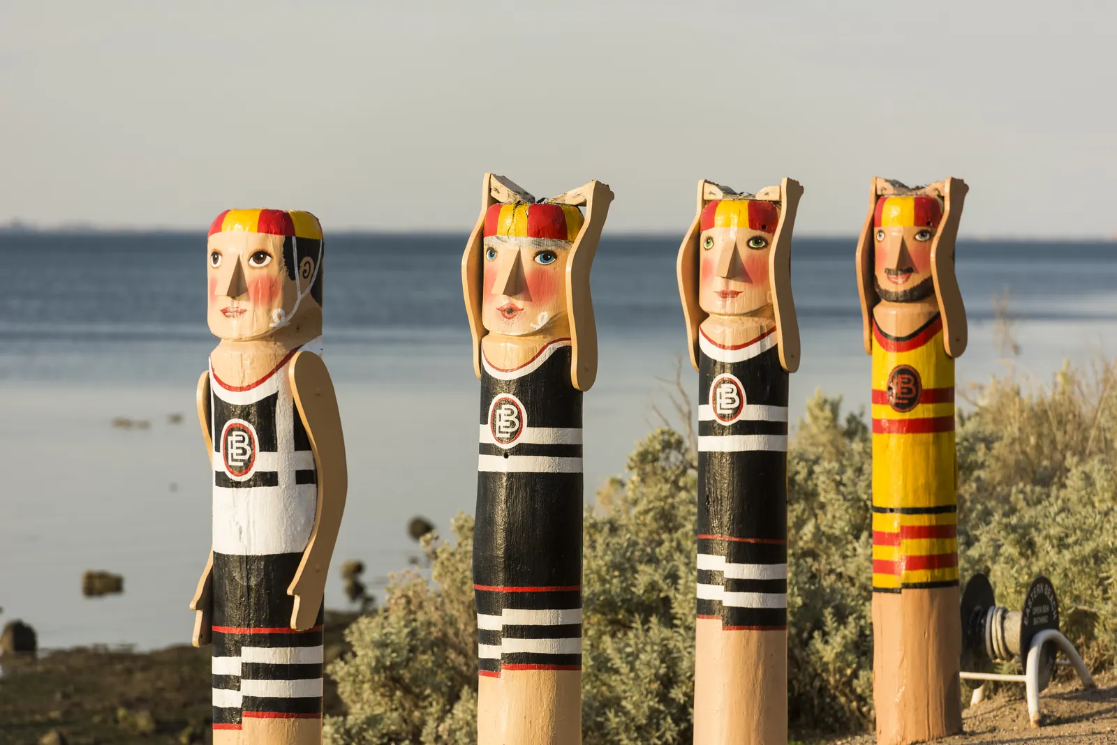 Colourful painted bollard figures beside the Geelong waterfront