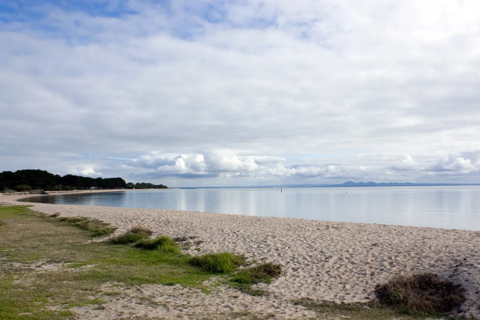 The calm bay beach at Portarlington on the Bellarine, under a cloudy sky
