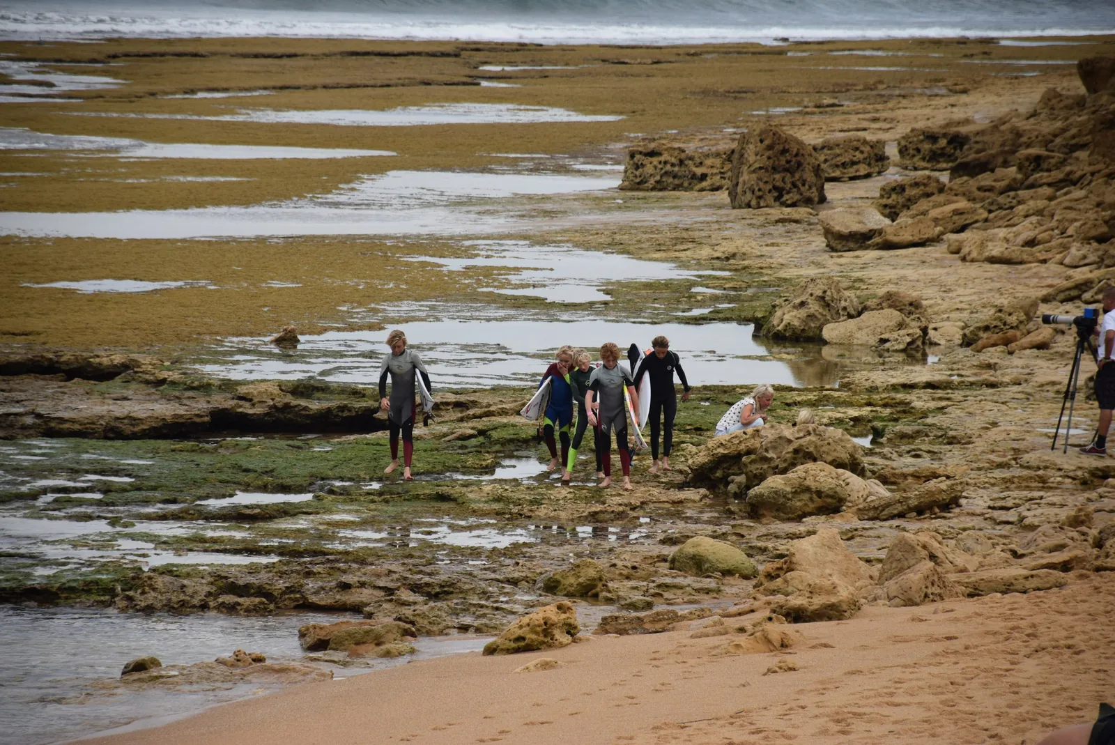 Surfers walking out across the reef at Bells Beach during the 2015 Rip Curl Pro
