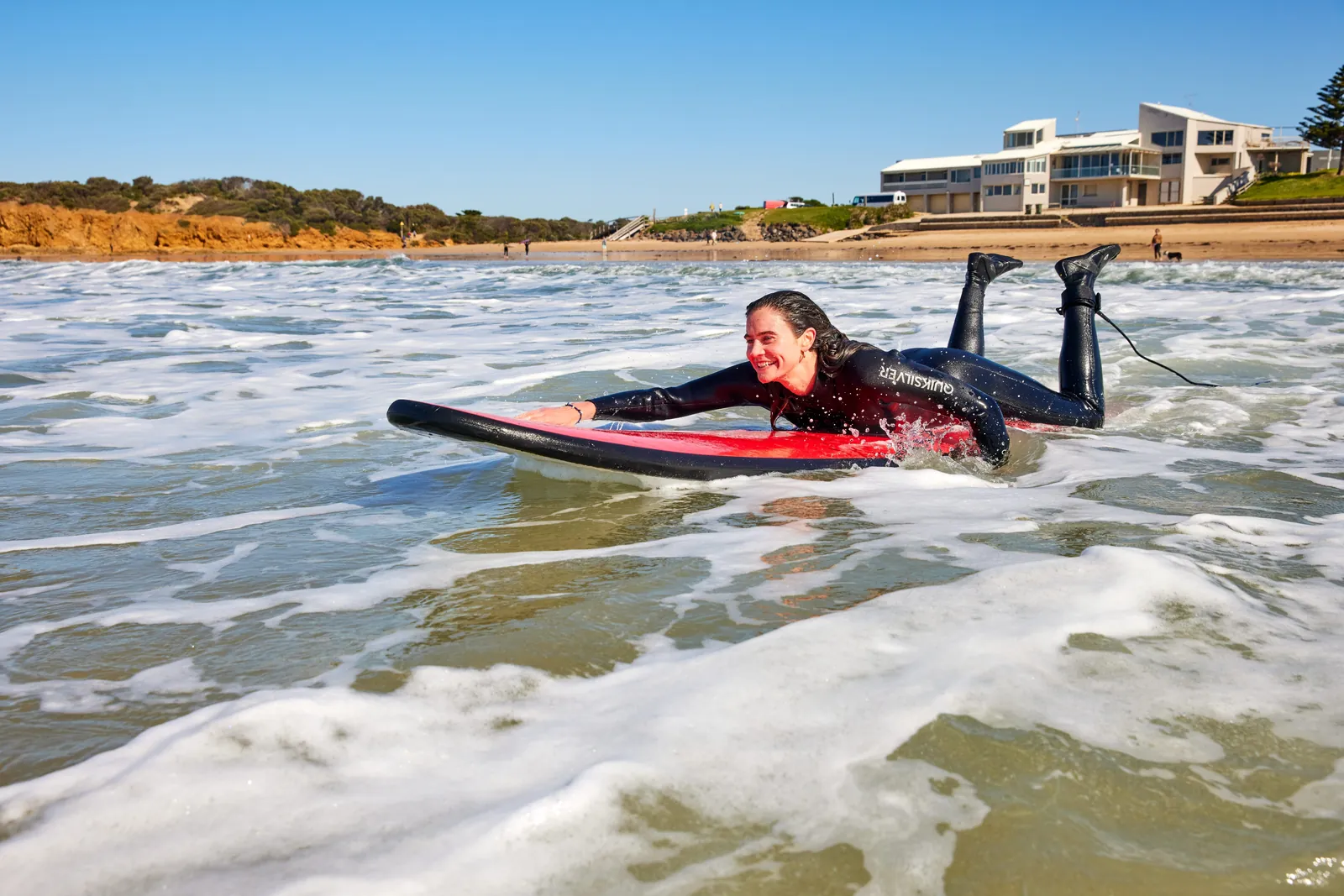 A learner paddling a soft-top board through whitewater at Torquay