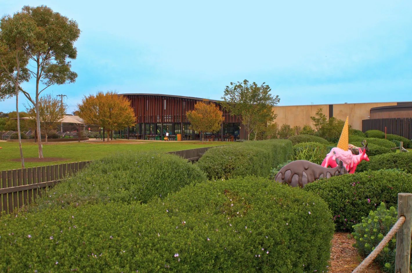 The Chocolateries building at Bellbrae behind its gardens, with a giant pink ice cream sculpture