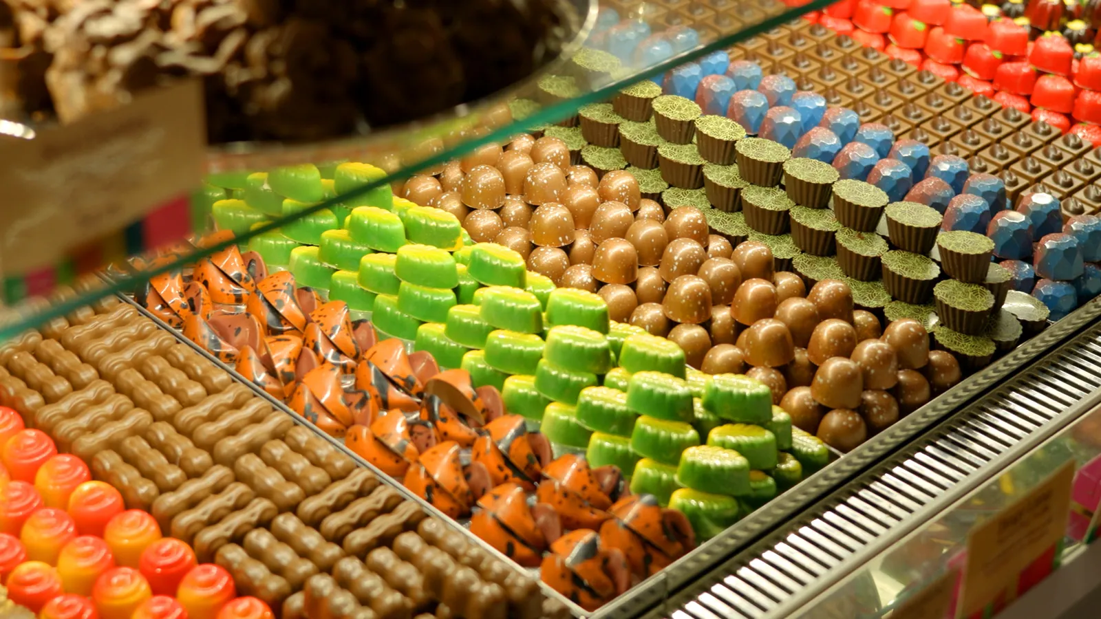 Rows of brightly coloured handmade chocolates in the showroom cabinet