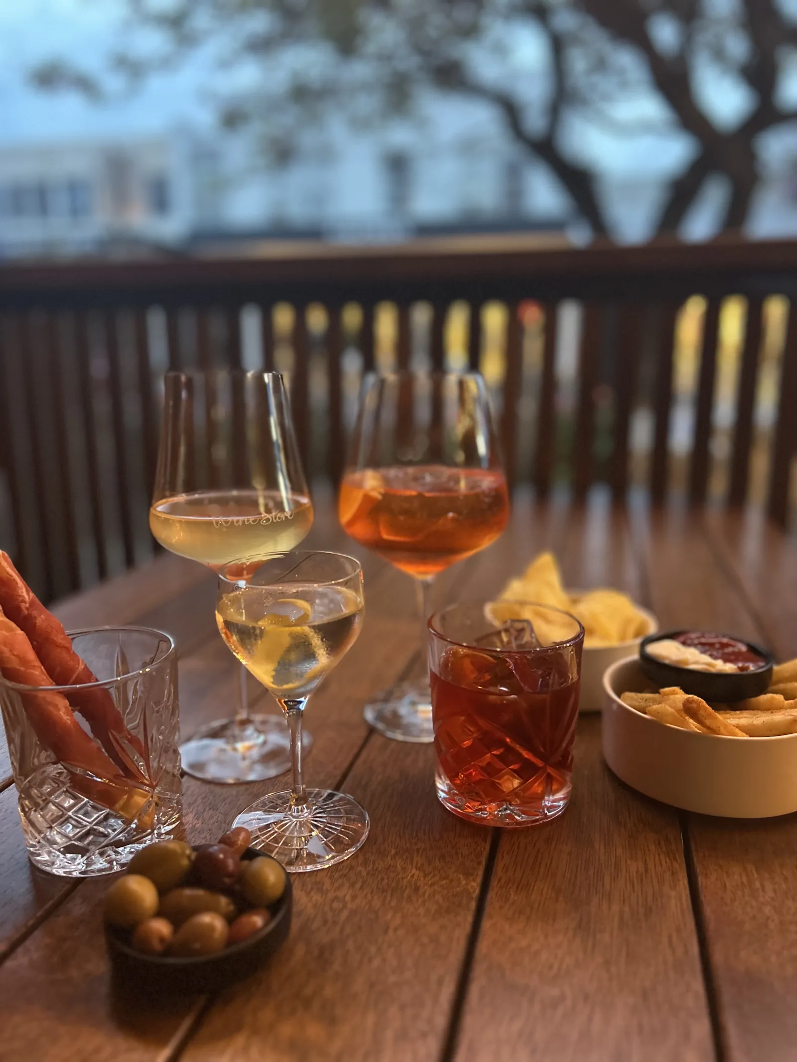 Glasses of wine and a spritz with olives on the front deck at Torquay Wine Store