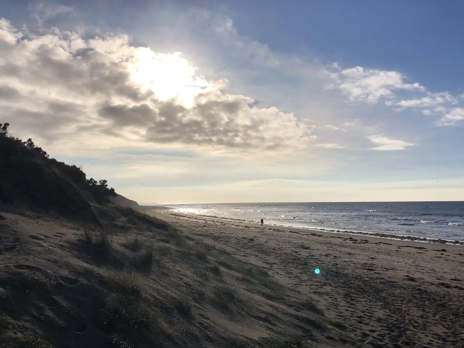 The long sandy beach east of Torquay, with dunes on the left under a bright sky