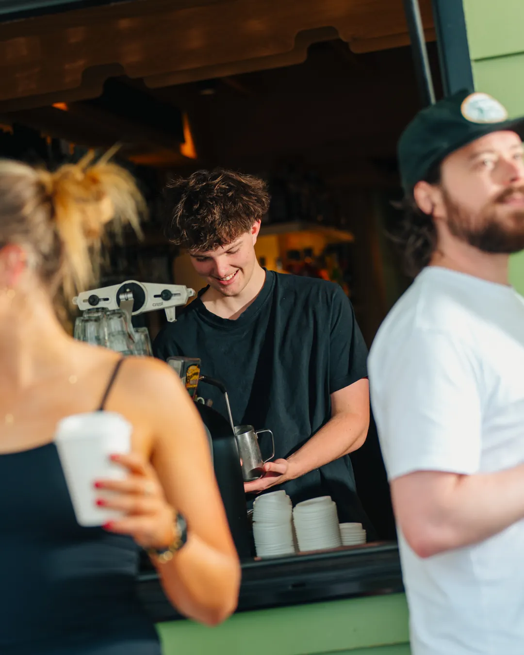 A barista making coffee at the Bomboras takeaway window