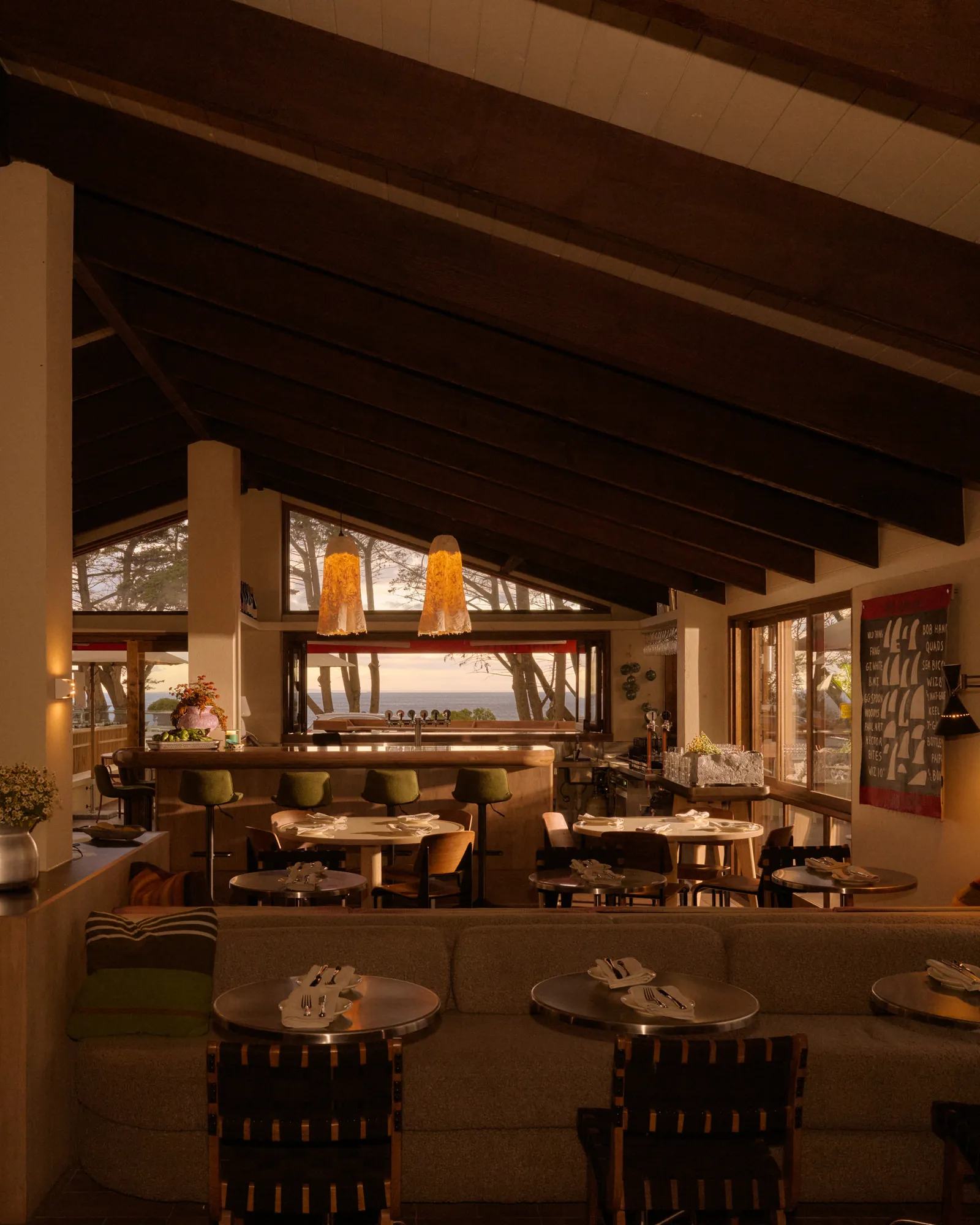 The Surf Hotel dining room at sunset, with the ocean through the far windows