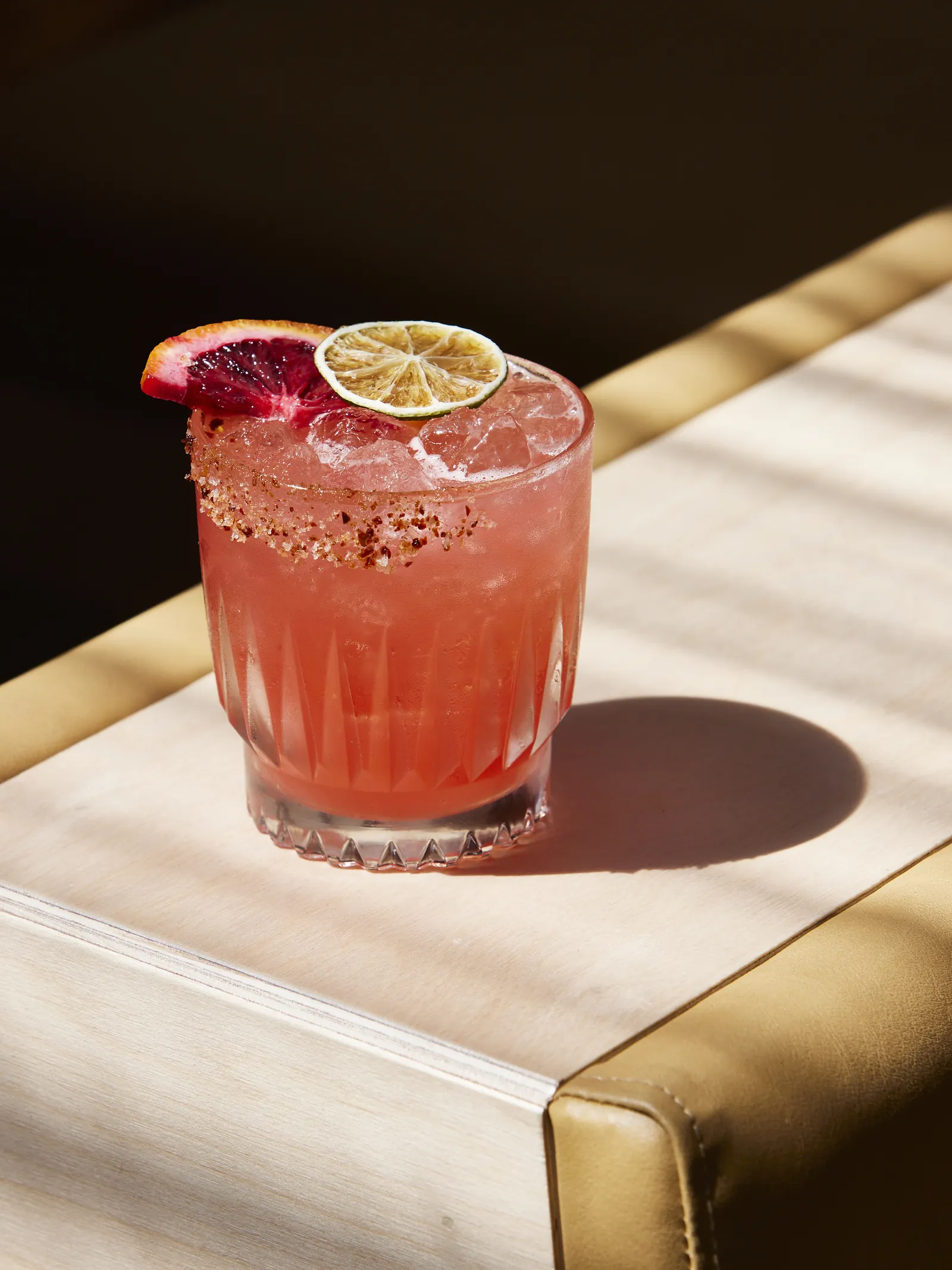 A pink cocktail with citrus slices on a table at The Kyn